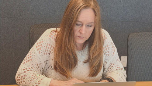 WCG staff member Jama Dock writing on her laptop